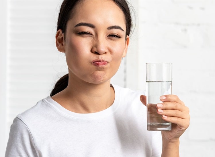 a woman rinsing her mouth with Warm Saltwater 